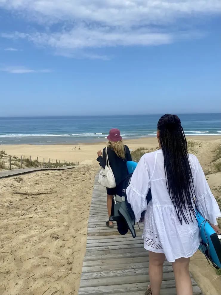 Participants d'un surfcamp dans le sud ouest de la France organisé par The Family Bike allant à un cours de surf quotidien.